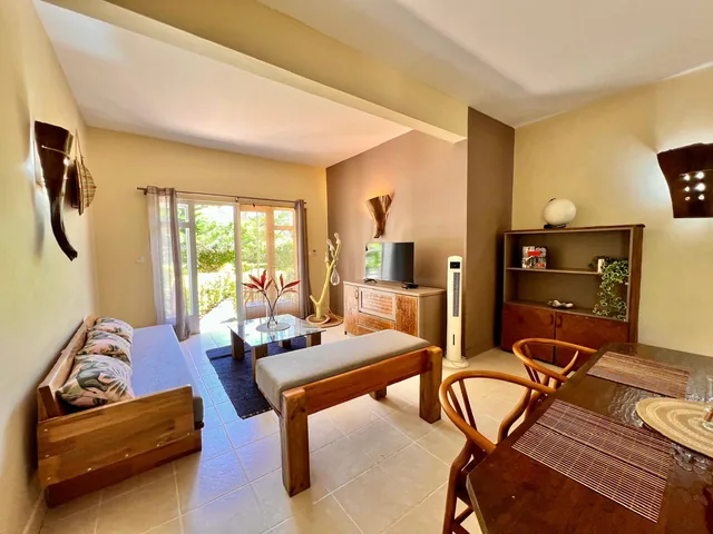 A lodge living room with sofas, a TV and a wooden dining table.