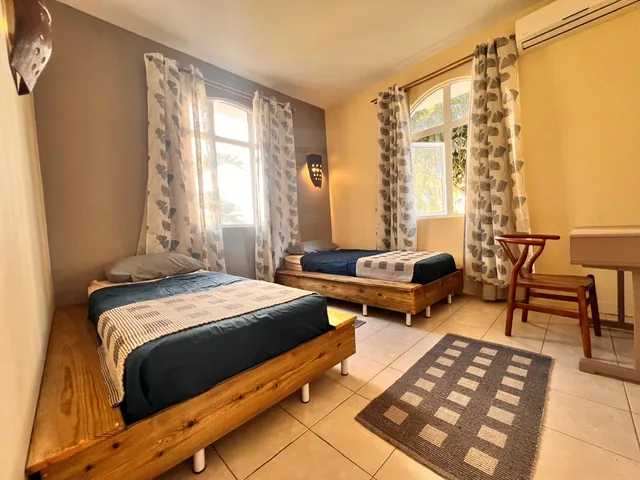 A lodge bedroom with two single beds and a desk.